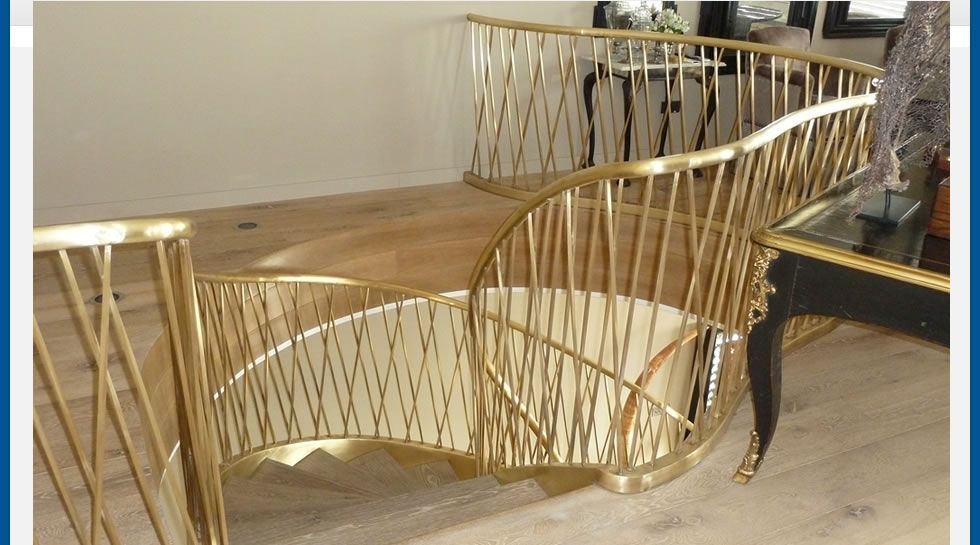 Barandilla dorada de diseño en escalera interior en Alicante